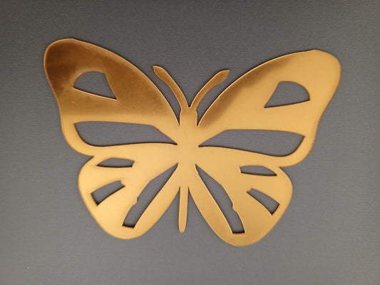 Gold butterfly-shaped object on a gray background