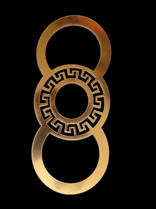 A circular shaped acrylic piece with a geometric design in the center, predominantly gold in color against a black background.