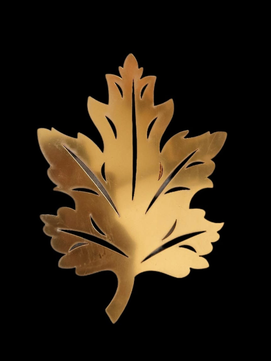 Gold leaf-shaped object on a black background