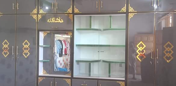 Large dark-colored wardrobe with gold accents with square shape design