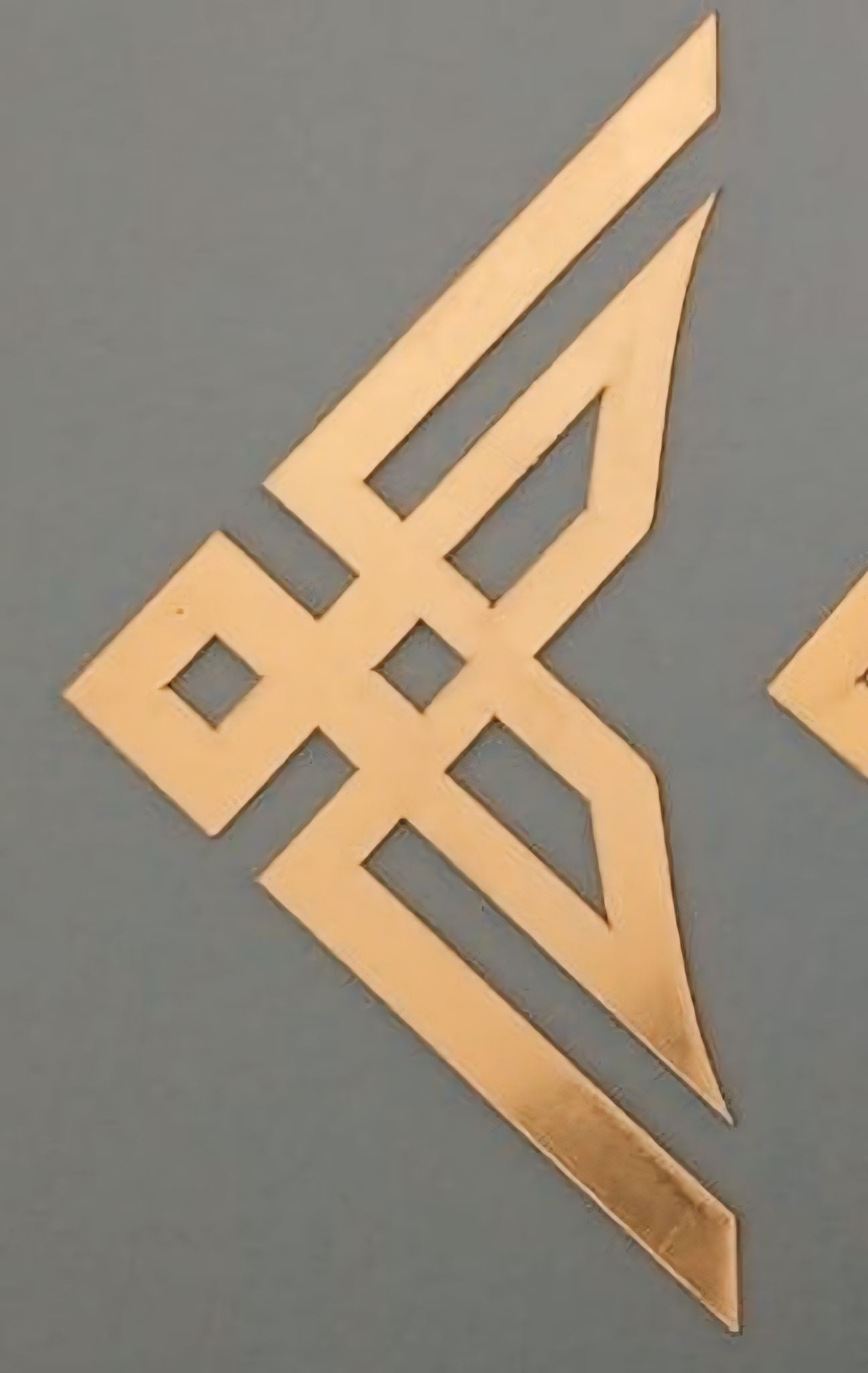 A gold-colored triangle-shaped acrylic T-1 craft base with a smooth surface on a grey background.